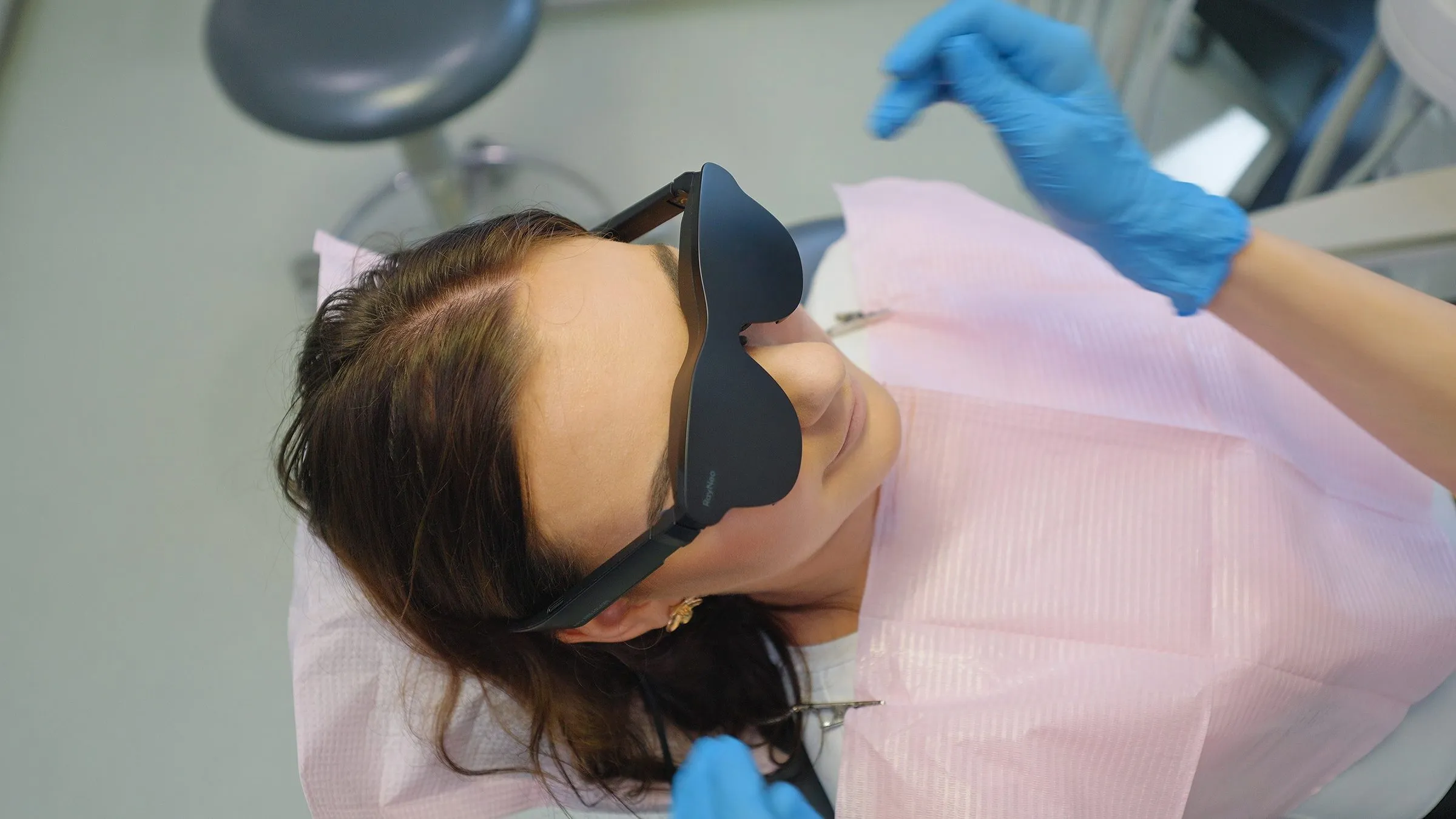 Pacjentka w okularach z ekranem Dental Glasses leży na fotelu stomatologicznym